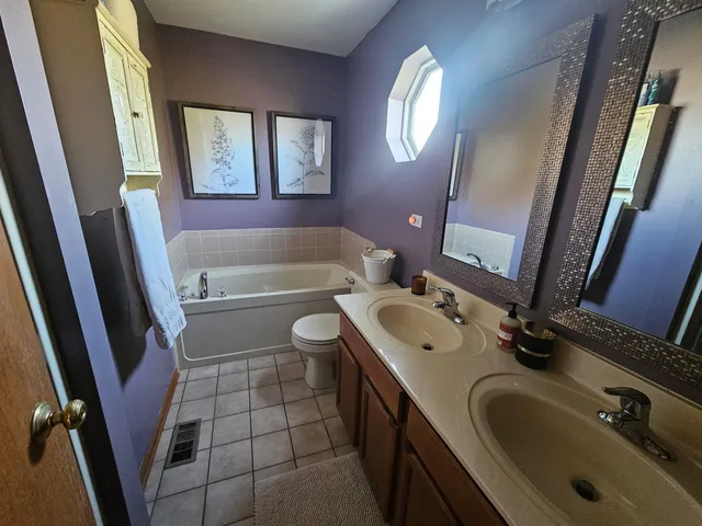 a bathroom with a sink a toilet a mirror and bathtub