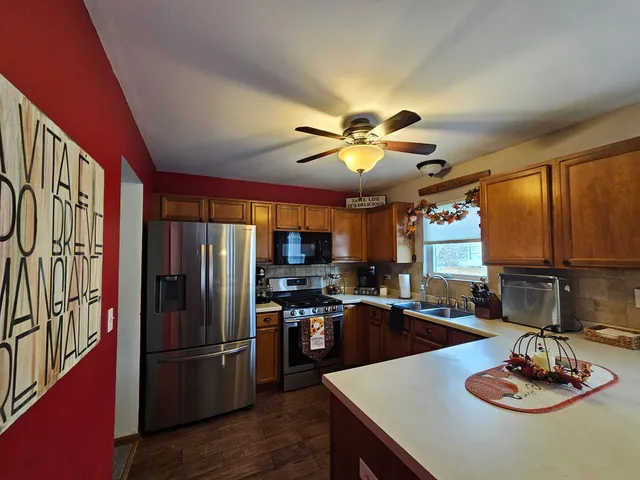 a kitchen with stainless steel appliances granite countertop a sink a stove and refrigerator