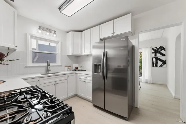 a kitchen with stainless steel appliances a stove a sink and a refrigerator