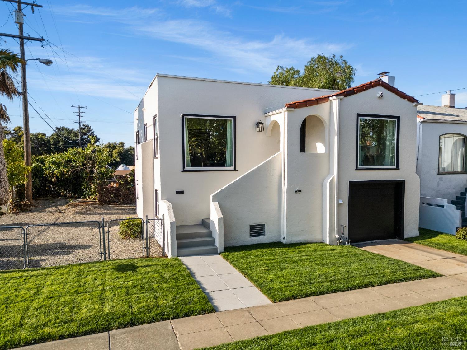 1402 Rice Street Vallejo, CA 94590 - Photo 6 of 55 a view of a white house with a small yard plants and large tree