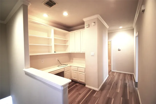 an empty room with wooden floor chandelier fan and windows