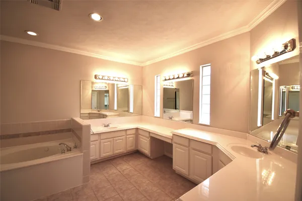 a bathroom with a tub sink and mirror