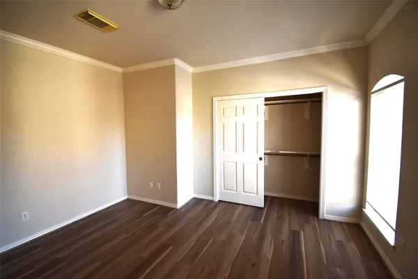 a view of empty room with wooden floor and window