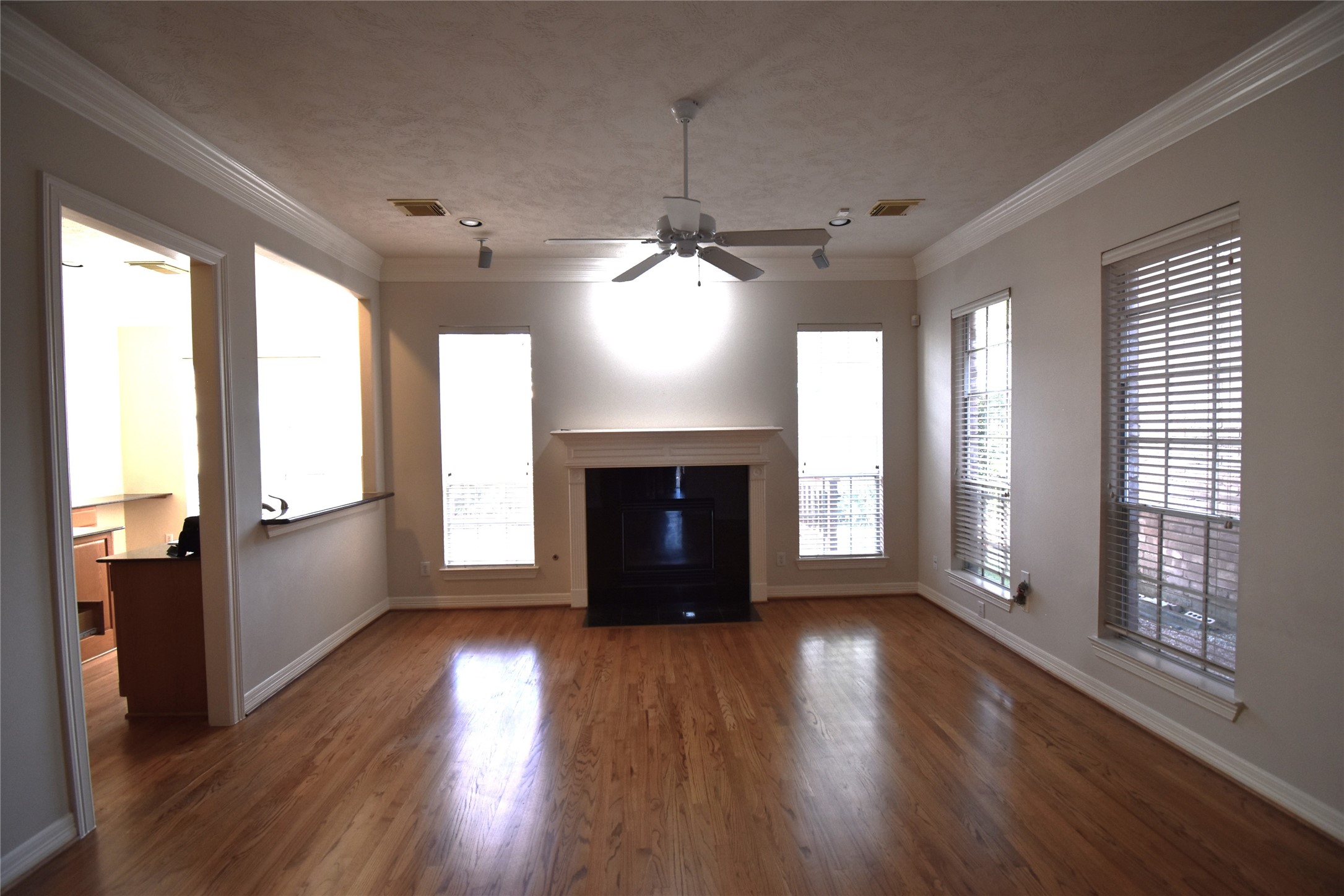 2835 Briarhurst Park Houston, TX 77057 - Photo 7 of 28 an empty room with wooden floor fireplace and windows