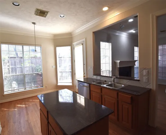a kitchen with stainless steel appliances granite countertop a sink a stove and a refrigerator