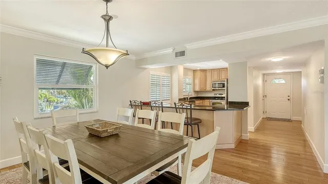 a view of a dining room and livingroom with furniture wooden floor a chandelier