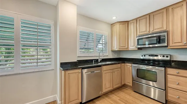 a kitchen with granite countertop white cabinets and appliances