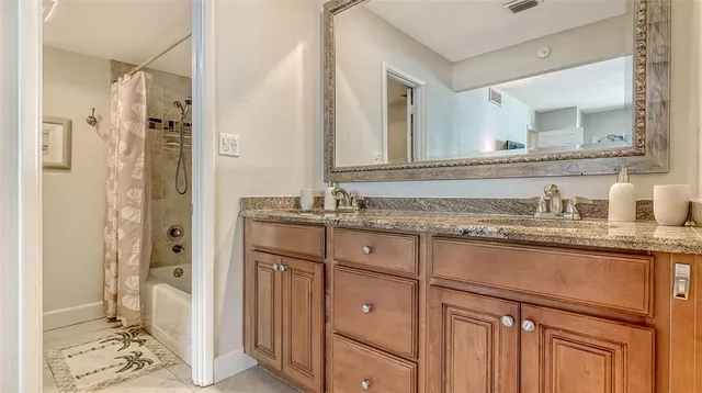 a bathroom with a granite countertop sink and a mirror