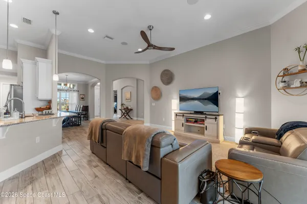 a living room with furniture a fireplace and kitchen view