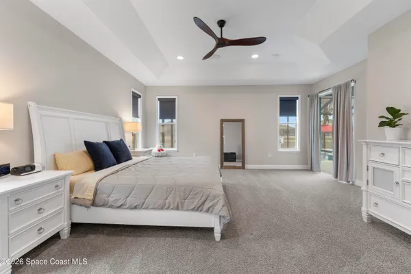a bedroom with a large bed and a chandelier