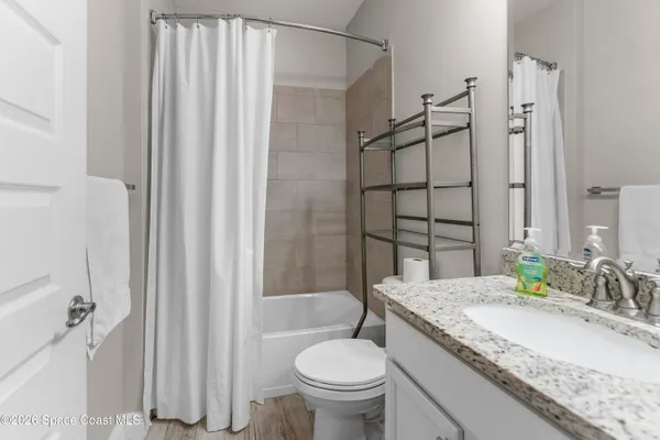 a bathroom with a granite countertop sink toilet and shower
