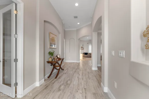 a view of a hallway with wooden floor and furniture