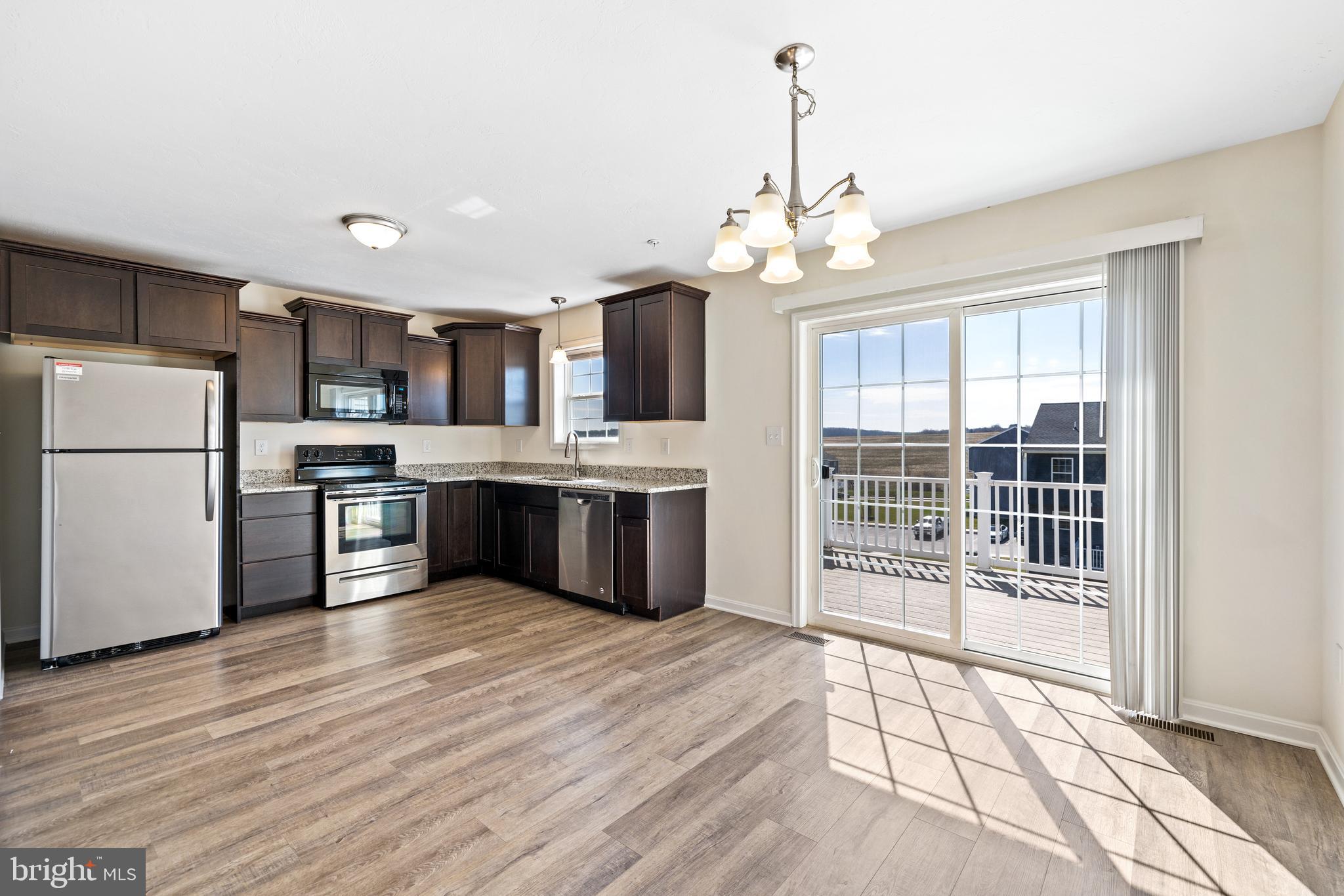 776 Rising Sun Lane Chambersburg, PA 17202 - Photo 5 of 25 a large kitchen with granite countertop a large counter top stainless steel appliances and a chandelier