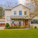 a front view of a house with a garden and plants