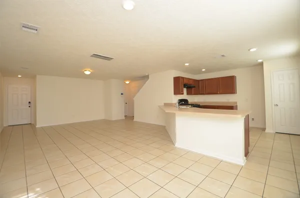 a view of kitchen and empty room with windows
