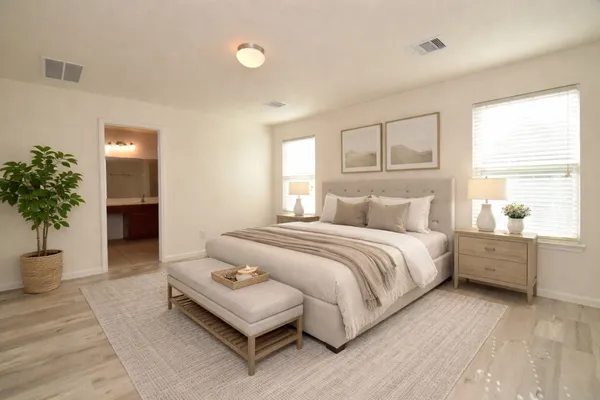 a spacious bedroom with a large bed and a potted plant