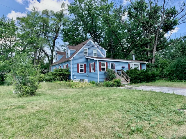 a front view of a house with a yard and trees