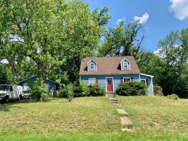 a front view of a house with a yard and trees