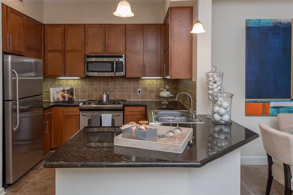 a kitchen with kitchen island granite countertop a sink a stove and a refrigerator