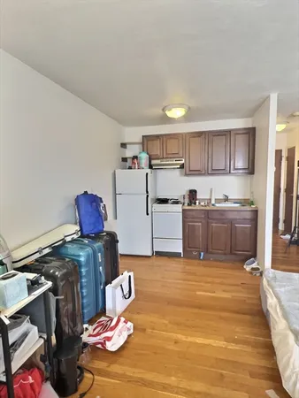 a kitchen with stainless steel appliances granite countertop a sink dishwasher stove and refrigerator with wooden floor