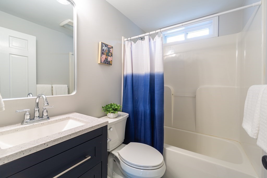 2 A Circular Avenue Natick, MA 01760 - Photo 16 of 29 a bathroom with a sink a toilet a mirror a vanity and shower
