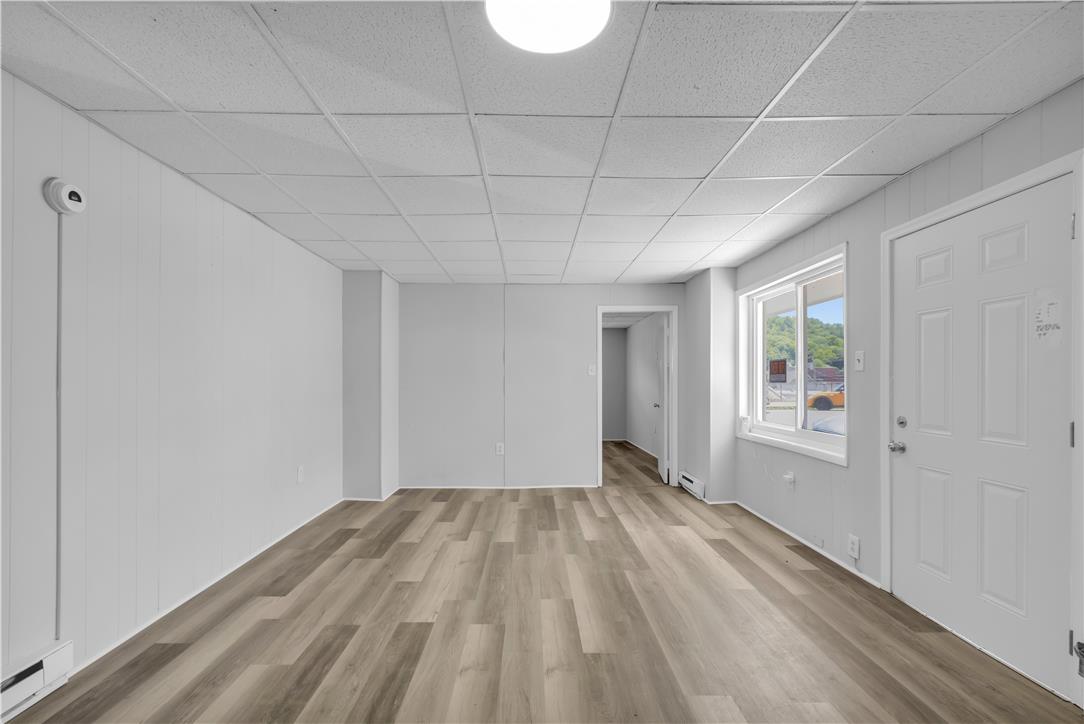 149 West Ridge Street, Unit 2A Lansford, PA 18232 - Photo 9 of 14 A versatile open area showcases wood-look plank flooring and paneled walls alongside natural window light.