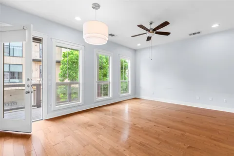 a view of an empty room with a window and wooden floor