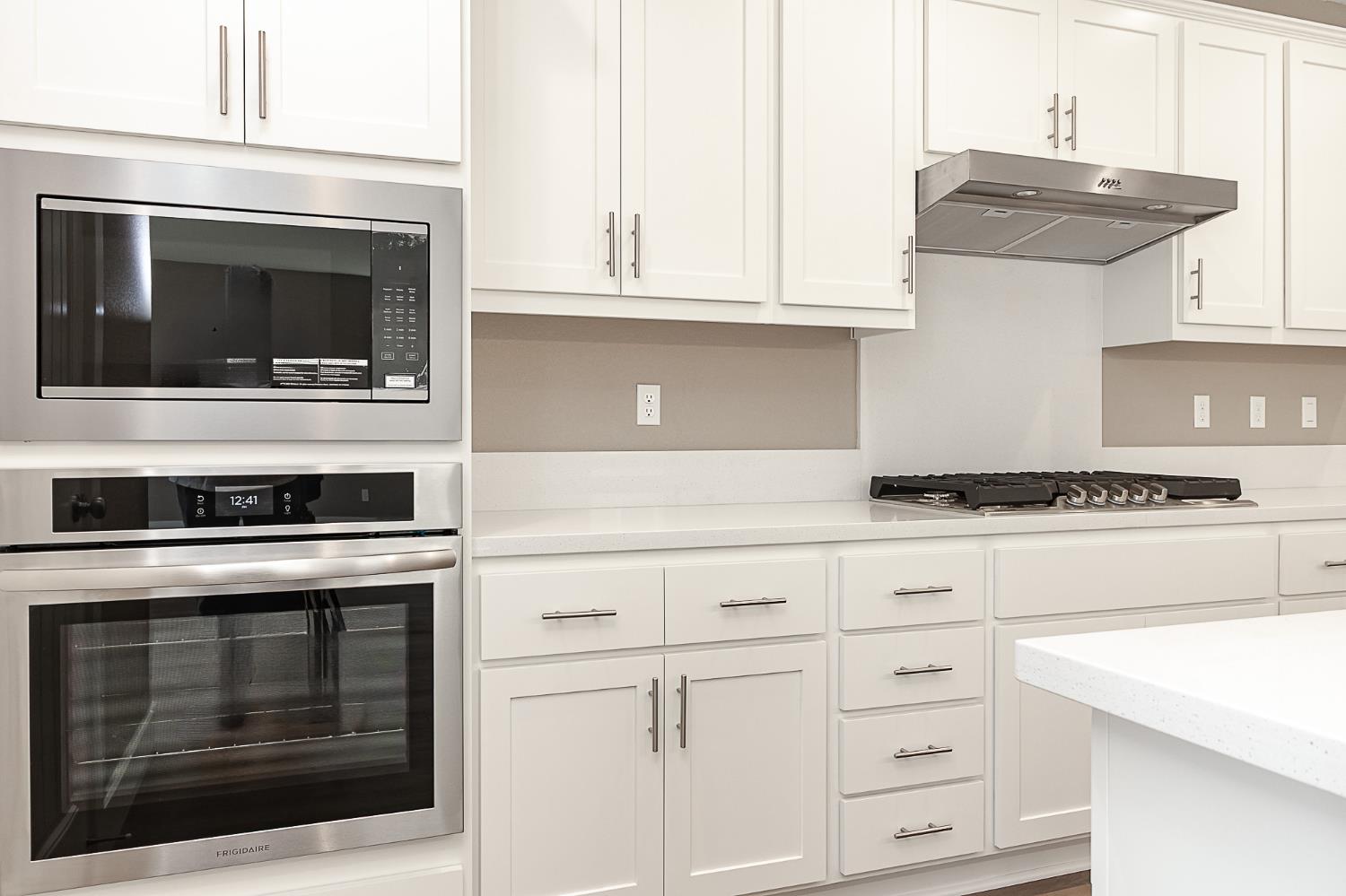 1310 Veteran Street Manteca, CA 95337 - Photo 14 of 33 a kitchen with white cabinets and stainless steel appliances