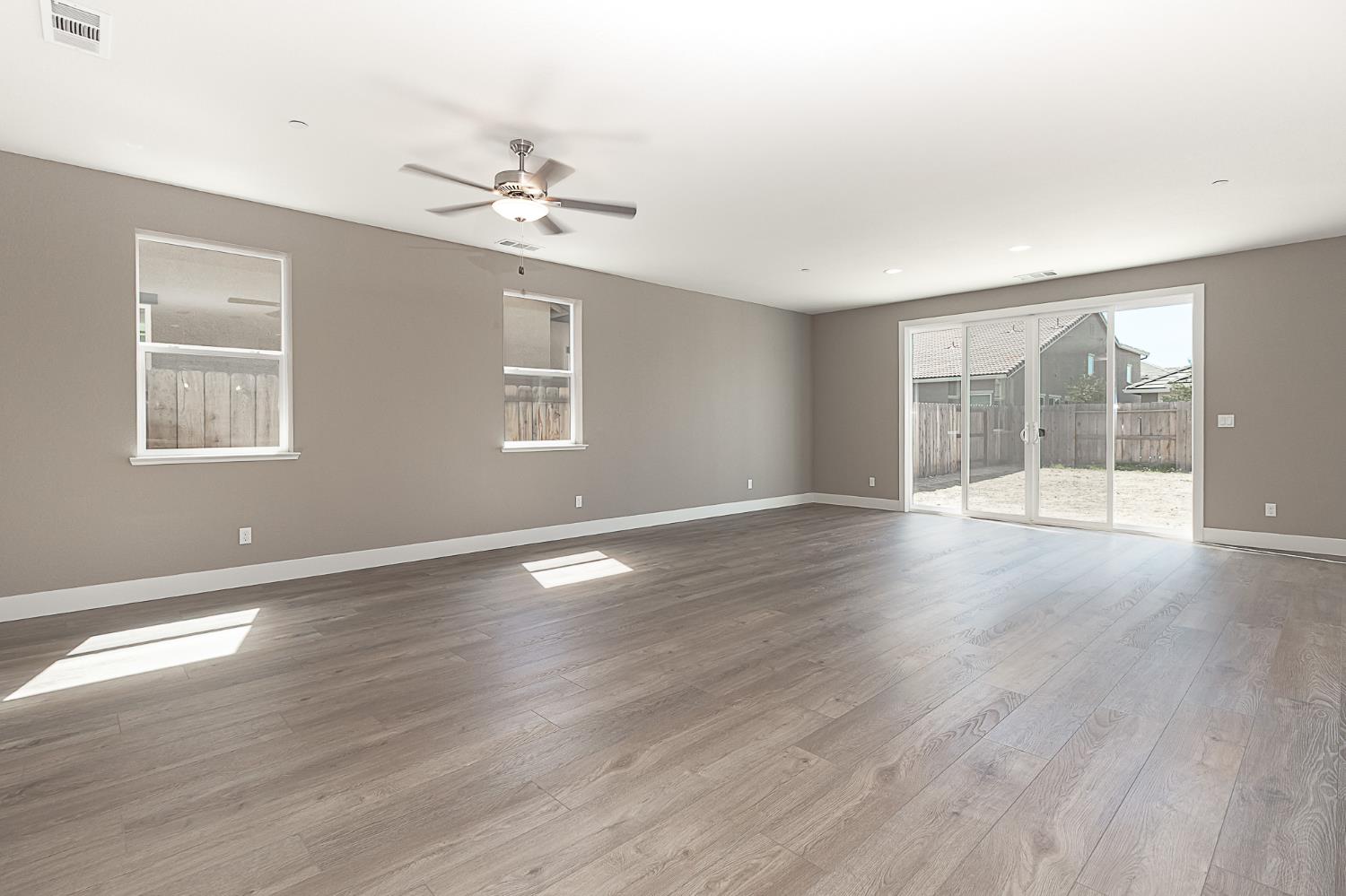 1310 Veteran Street Manteca, CA 95337 - Photo 17 of 33 an empty room with wooden floor and windows