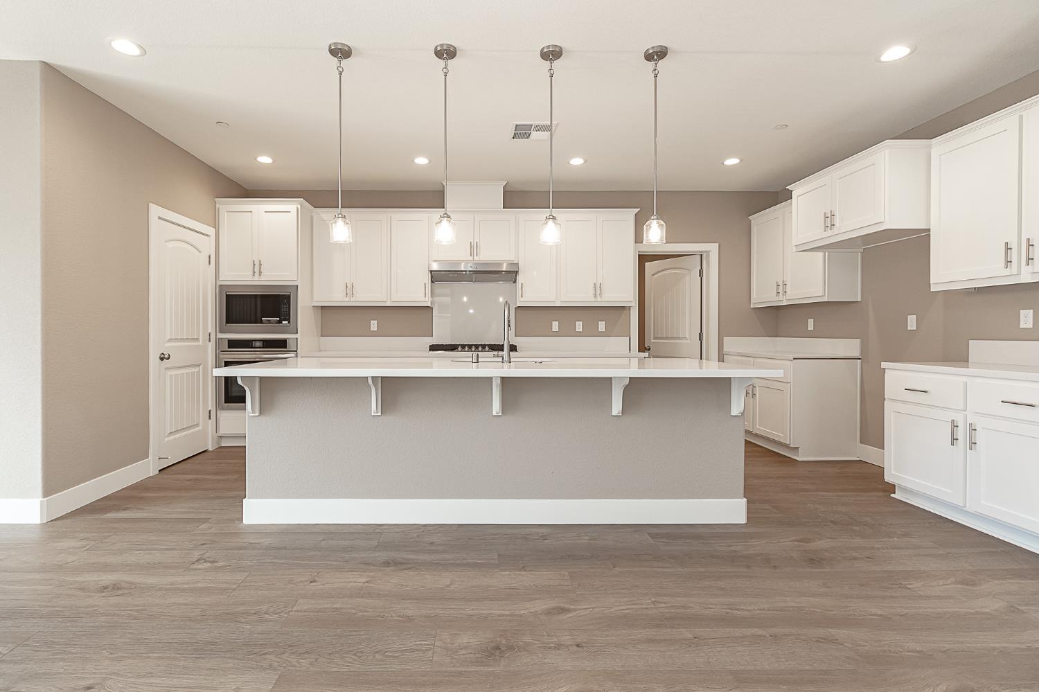 1310 Veteran Street Manteca, CA 95337 - Photo 10 of 33 a large kitchen with stainless steel appliances granite countertop a stove a sink and a refrigerator
