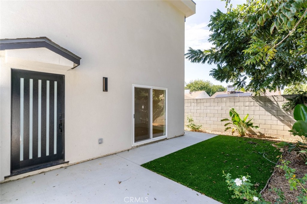 a view of an house with backyard space and a tree