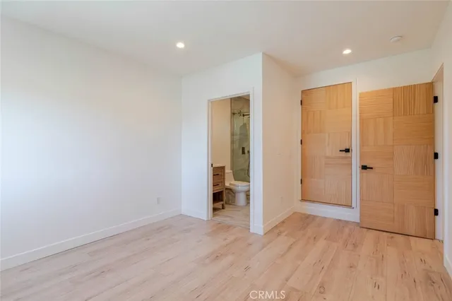 an empty room with wooden floor and closet