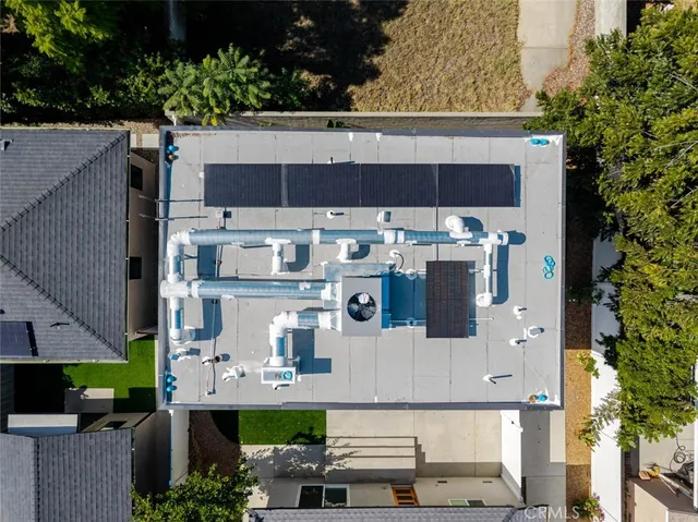 an aerial view of residential house with parking and trees