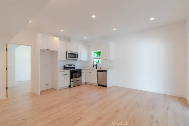 a kitchen with a refrigerator and a stove top oven