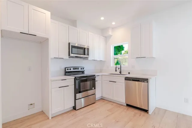 a kitchen with a sink cabinets and stainless steel appliances