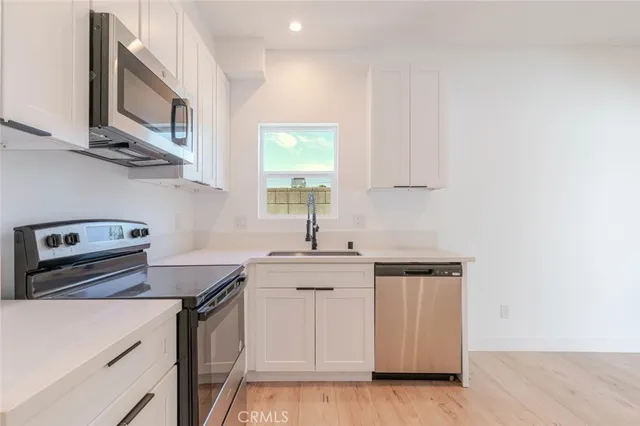 a kitchen with stainless steel appliances a sink a stove and cabinets