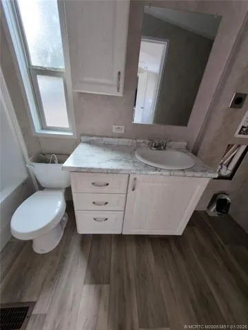 a bathroom with a granite countertop toilet sink and mirror