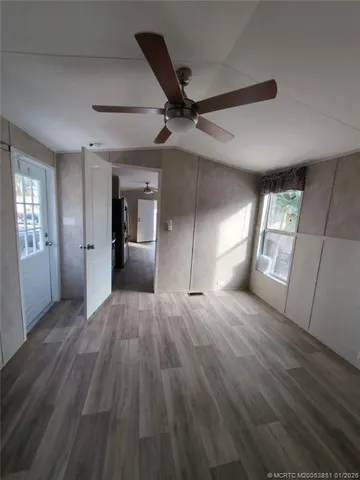 a view of an empty room and window and wooden floor