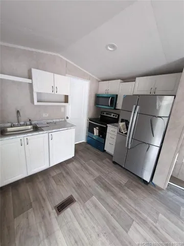 a kitchen with wooden floors and appliances