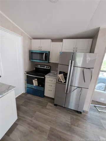a kitchen with a refrigerator sink and cabinets