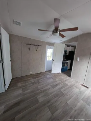 a view of an empty room with window and wooden floor