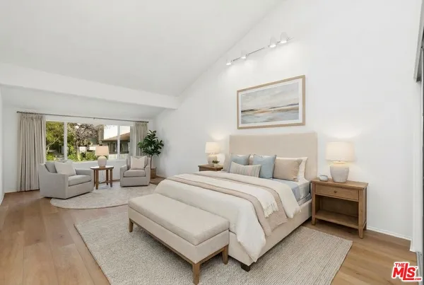 a bedroom with bed and a large window