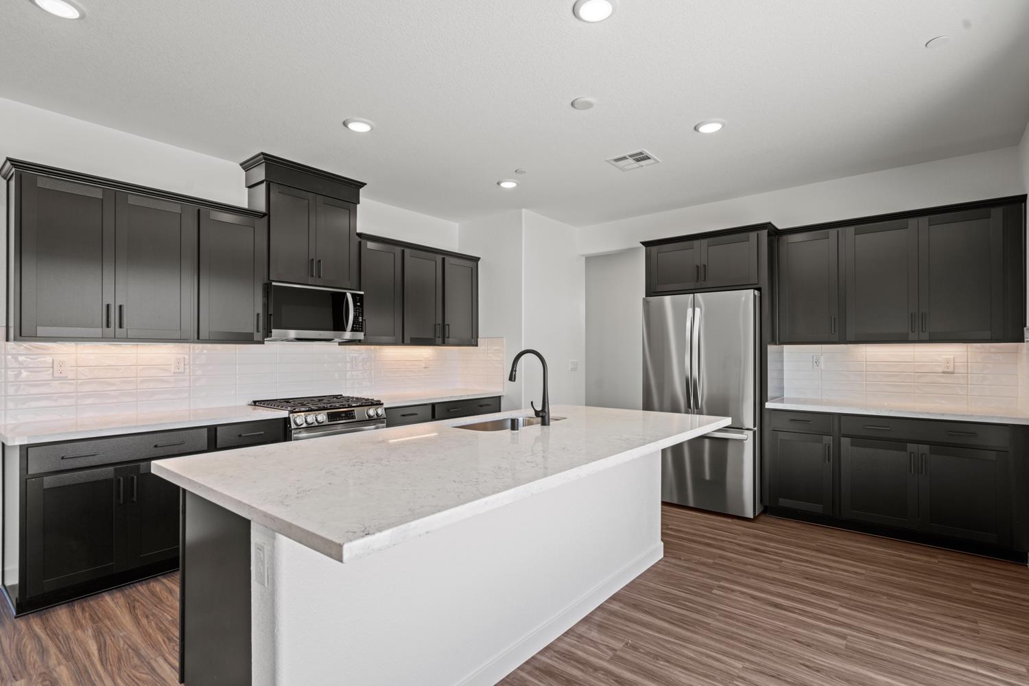1034 Slalom Way Lincoln, CA 95648 - Photo 3 of 15 a kitchen with stainless steel appliances a sink a stove a refrigerator and cabinets
