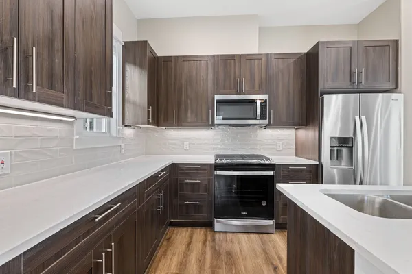 a kitchen with kitchen island granite countertop a sink stove and refrigerator
