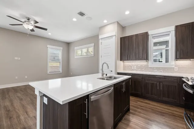 a kitchen with a sink a center island cabinets and a window