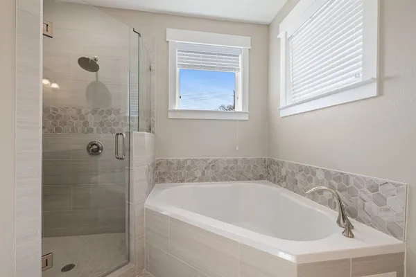 a white bath tub sitting next to a shower