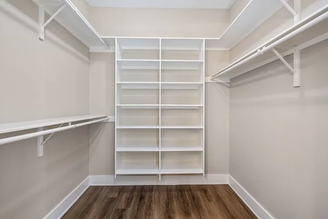 a view of walk in closet with empty racks