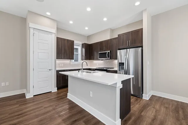 a kitchen with kitchen island a sink stainless steel appliances and cabinets