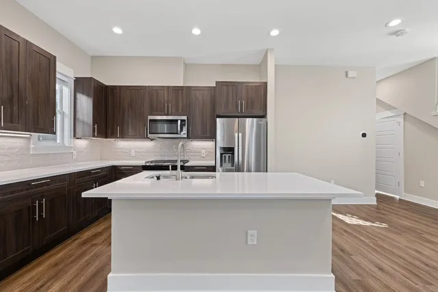 a kitchen with kitchen island a sink stainless steel appliances and cabinets