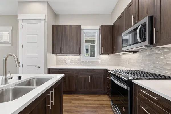 a kitchen with stainless steel appliances granite countertop a sink stove and cabinets